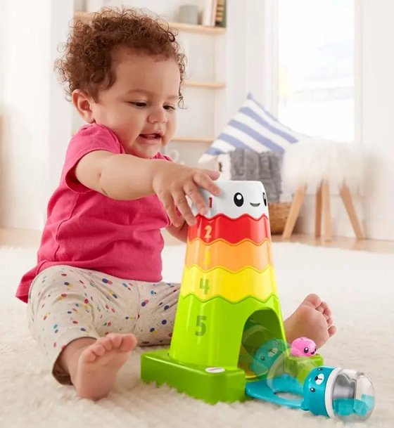 Young girl having fun stacking coloured blocks